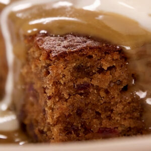 Sticky date pudding with butterscotch sauce running off the sides